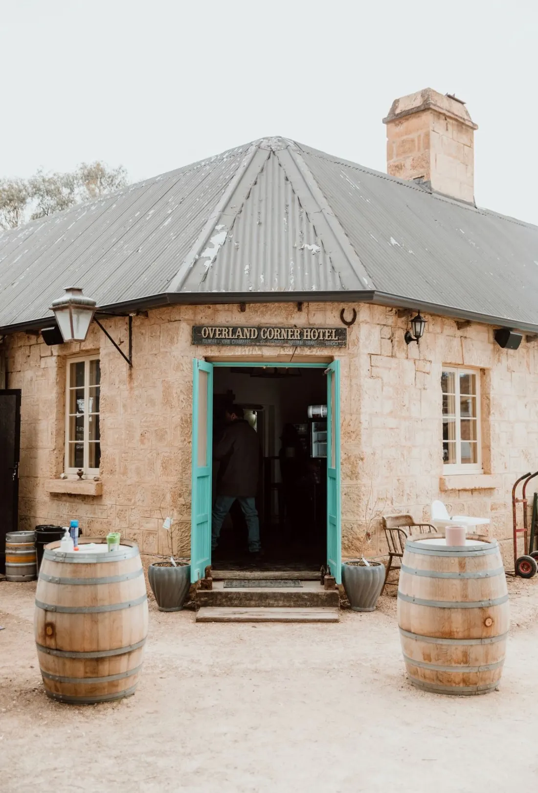 The limestone front of the hotel with its teal doors and barrels
