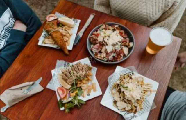 Plates and pints across a timber table